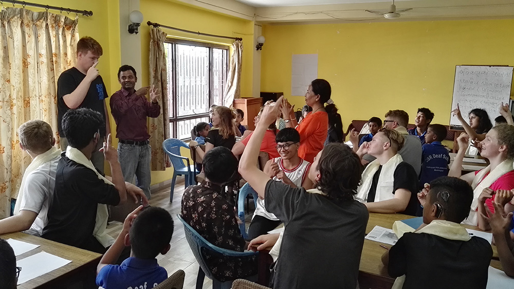 Callum teaching British Sign Language during the Mary Hare School Nepal trip with VoluntEars