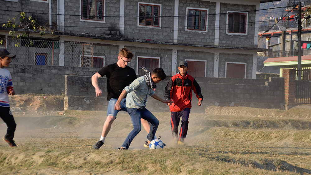 Ben playing football on a dry padi field during his Nepal trip with VoluntEars