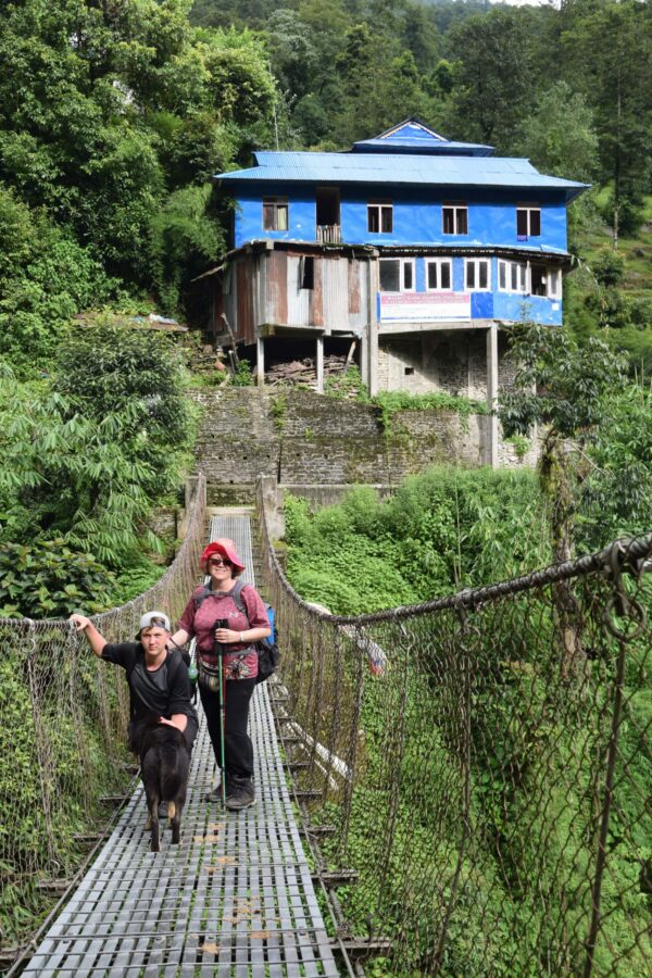 Donna and Noah on a bridge over a river during the trek in the Himalayan mountains with VoluntEars in Nepal
