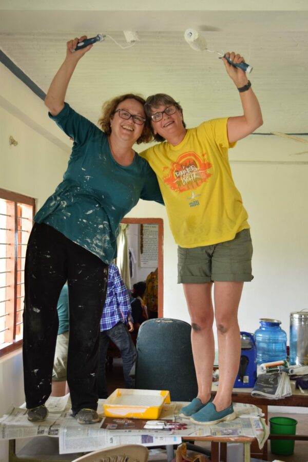 Donna (left) helping to paint the staff room at a Deaf school in Nepal