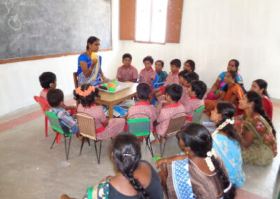 Indian teacher sitting with a class of deaf students at a Deaf school in south India