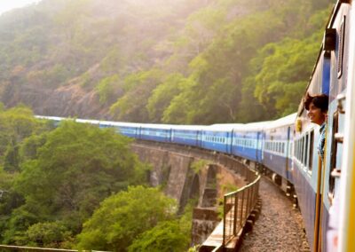 A long train travelling over a bridge in India