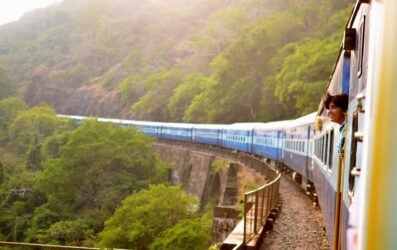 A long train travelling over a bridge in India