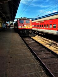 A red coloured Indian railway train waiting at a platform
